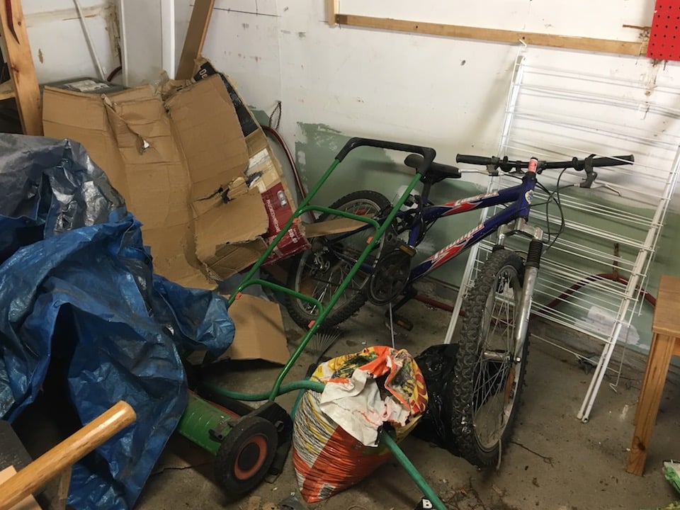 bike and push mower leaning against wall