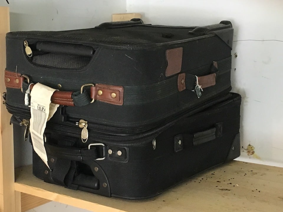 2 black suitcases on shelf