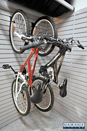 sports equipment storage 2 bikes hanging on wall