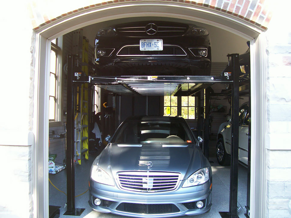 black Mercedes on a car lift in a single car garage