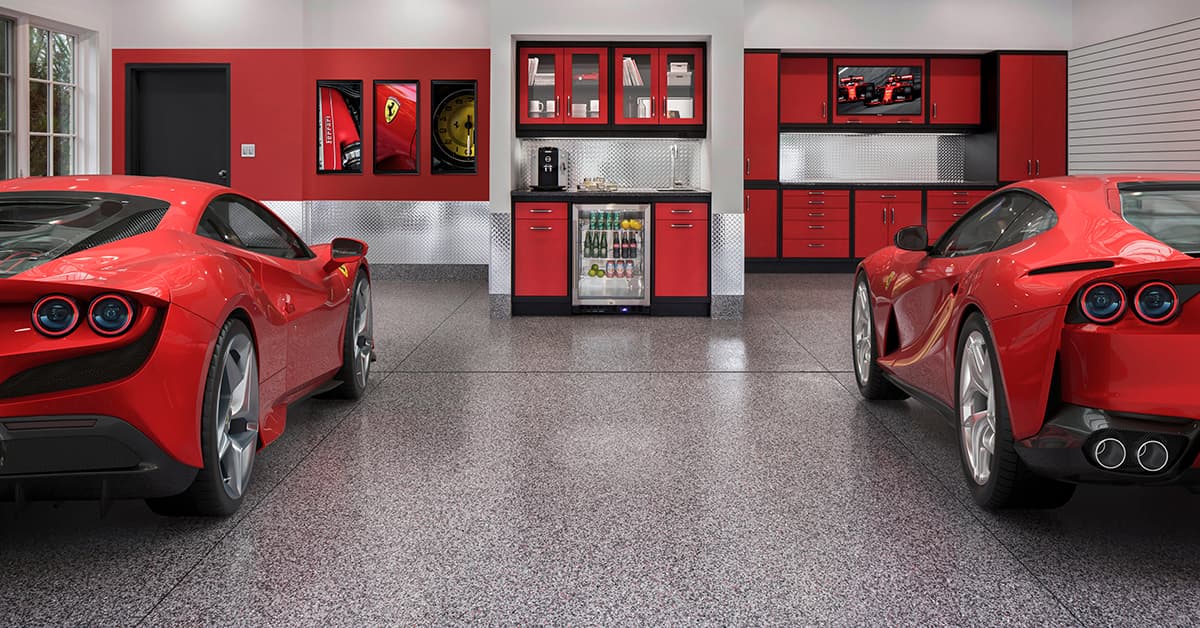 two ferraris parked in garage with red cabinets