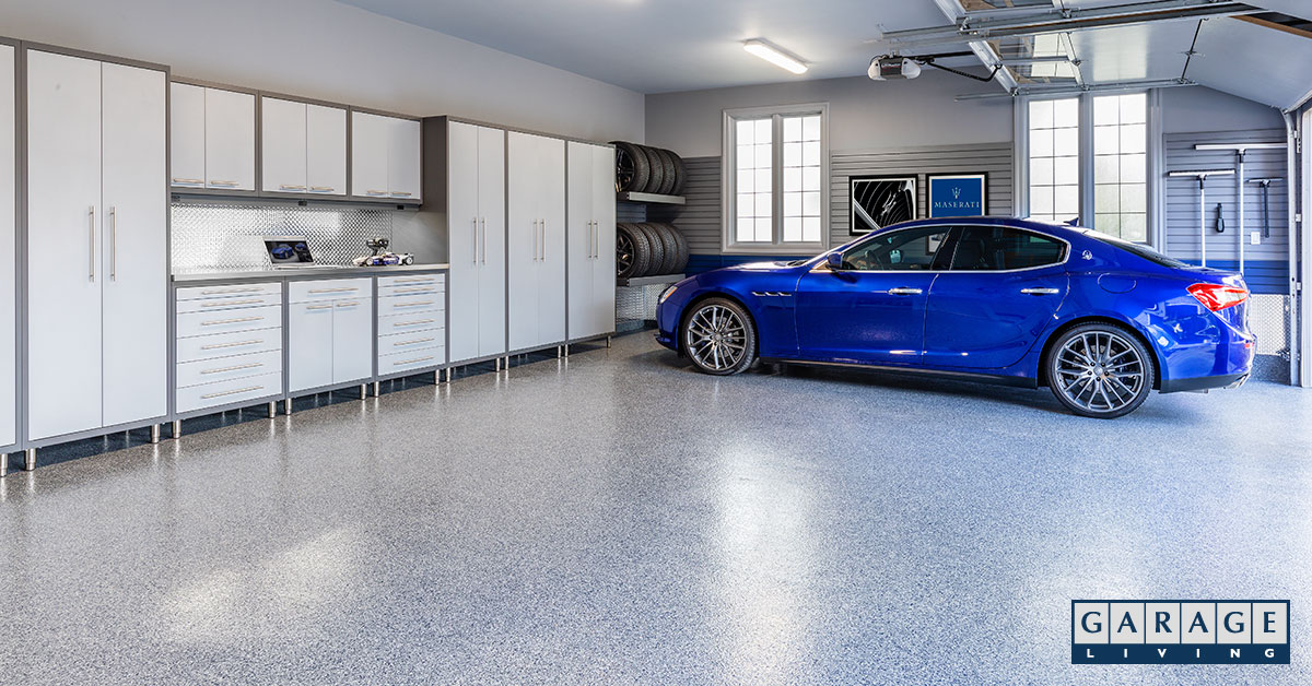 Tidy 3-car garage with cabinets, tire rack, blue Maseratti.