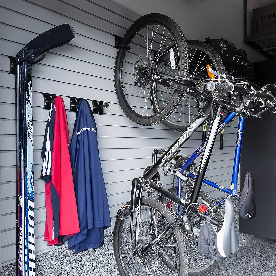 hockey sticks and bicycle rack on garage wall