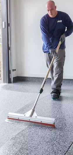 man applying garage floor sealer