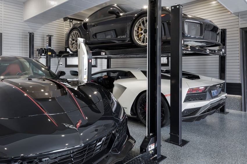 Garage with double car lift and overhead storage solutions for maximizing vertical space