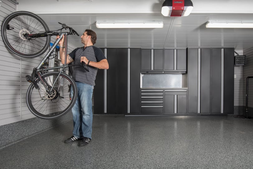 Wall-mounted garage bike storage system with organized cycling gear and slatwall accessories.