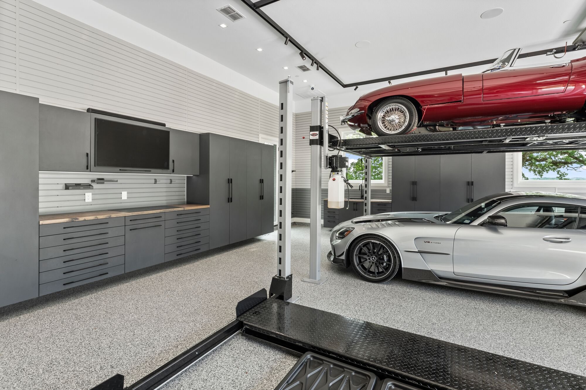 Two car lifts enable the homeowner of this garage to store up to 6 vehicles. More parking. More fun!