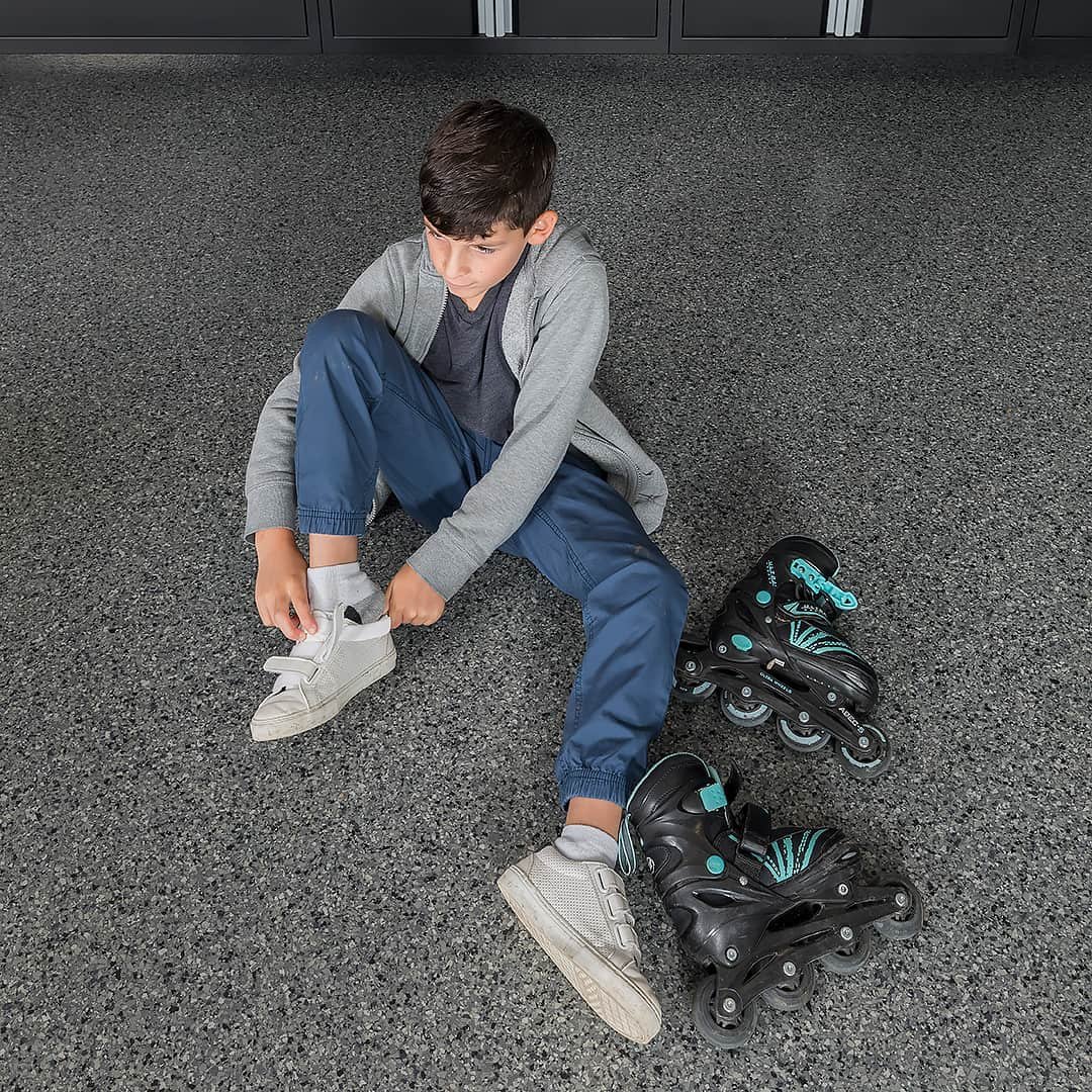 boy-sitting-on-garage-floor-rollerblades