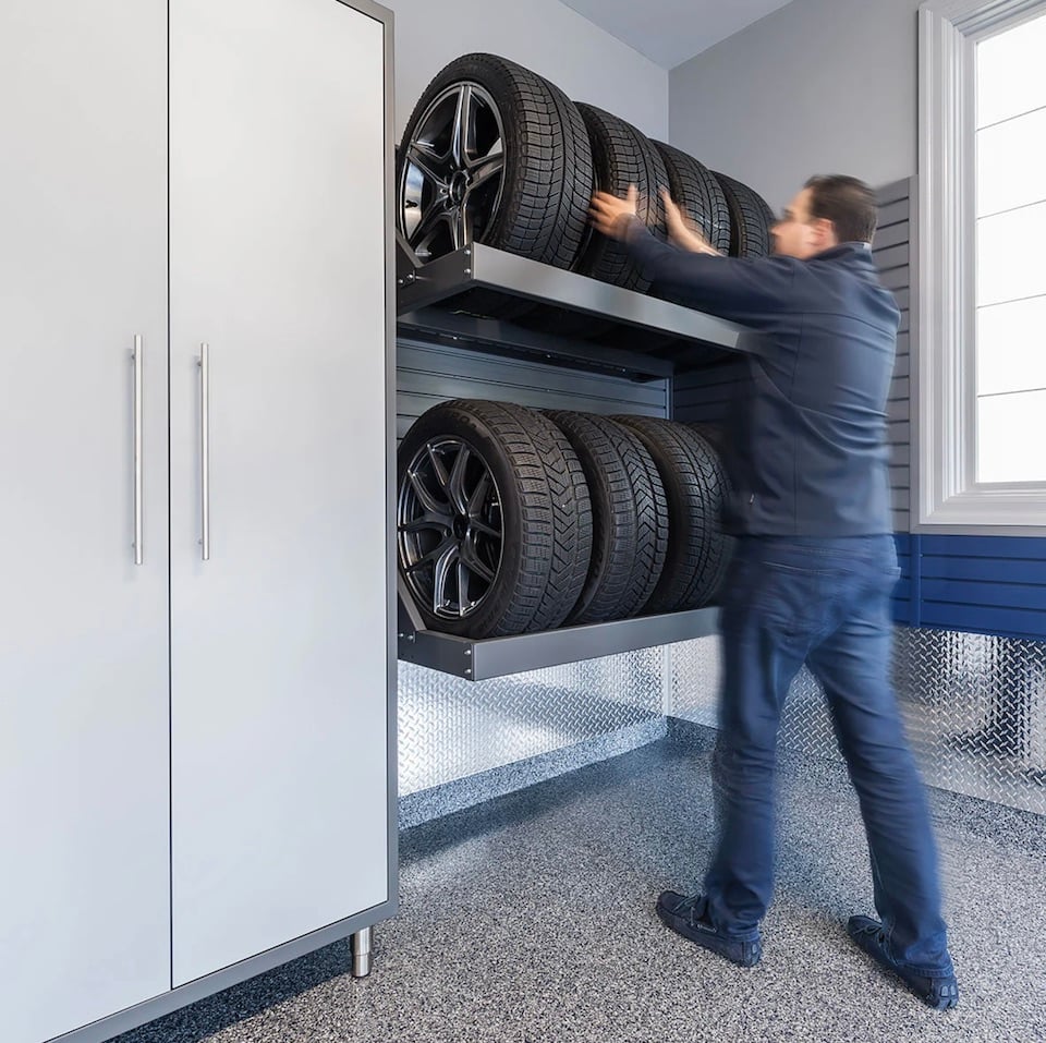 man putting tire on rack