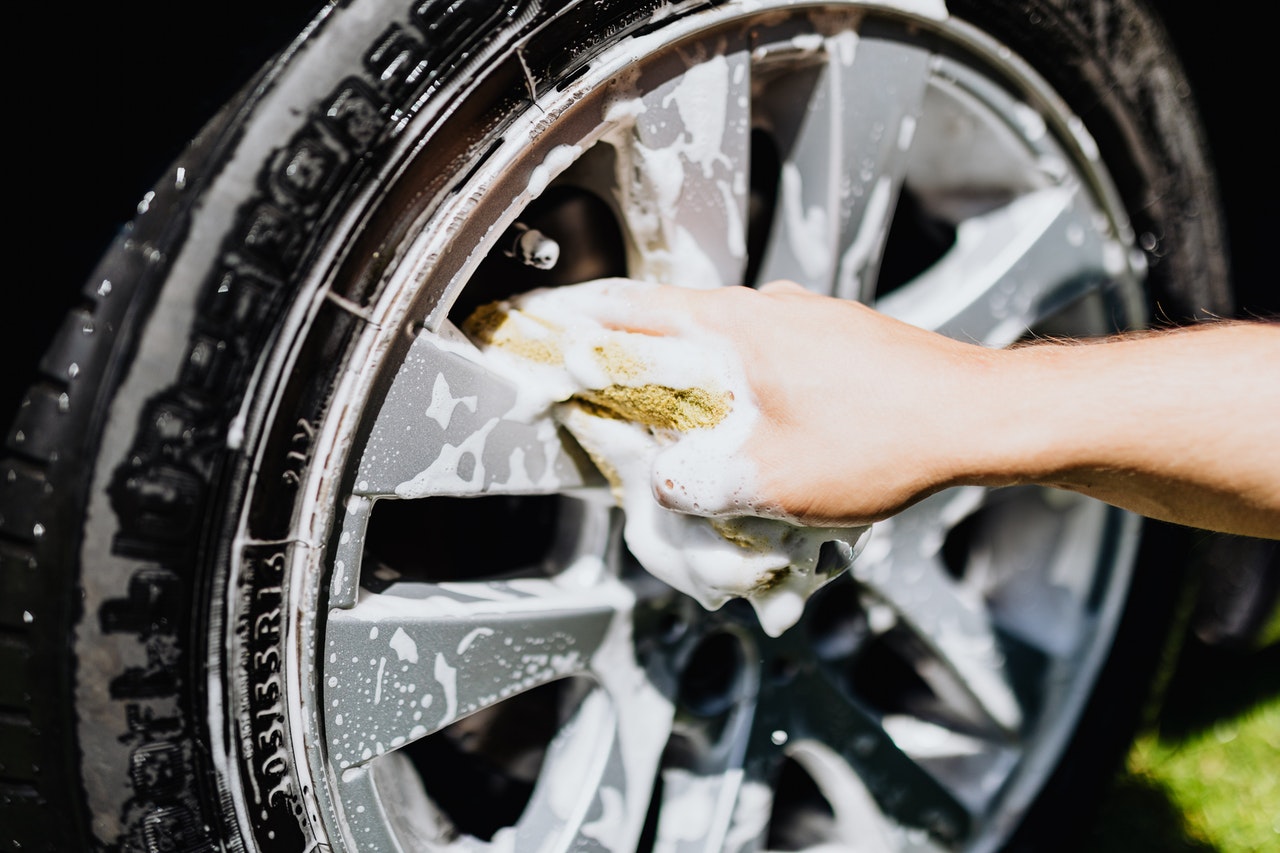 person cleaning car tire