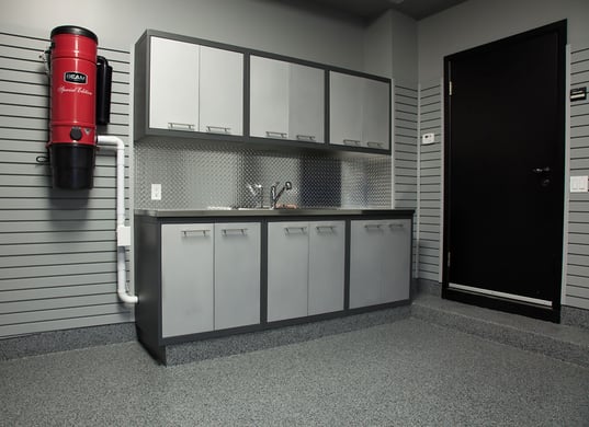 A Floortex® floor coating in Nightfall was applied to the floor, foundation walls, a wide step and a custom kick plate below the cabinets. GL Premium cabinetry in silver and granite provide storage.