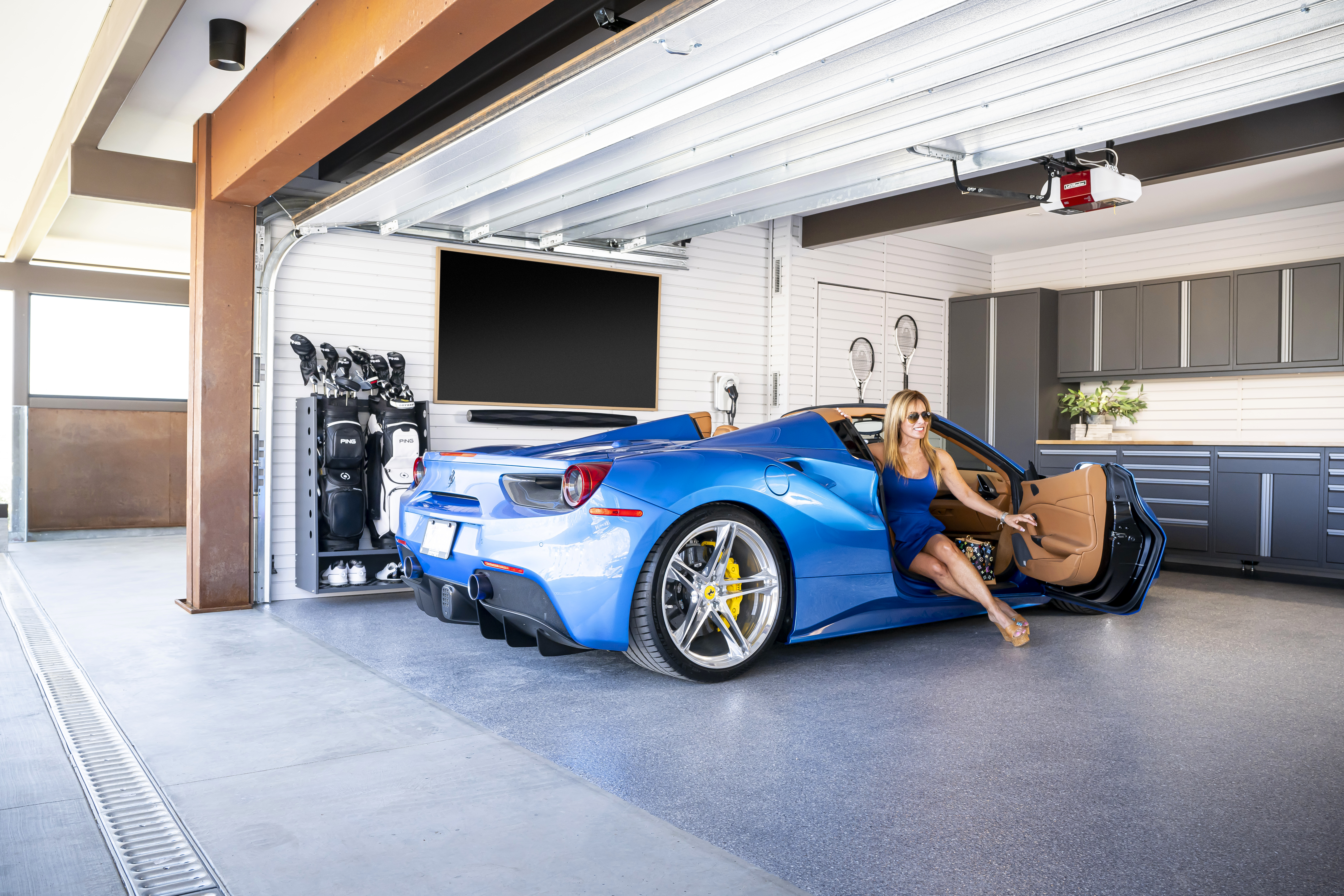 Spacious garage featuring woman in the car by Garage Living