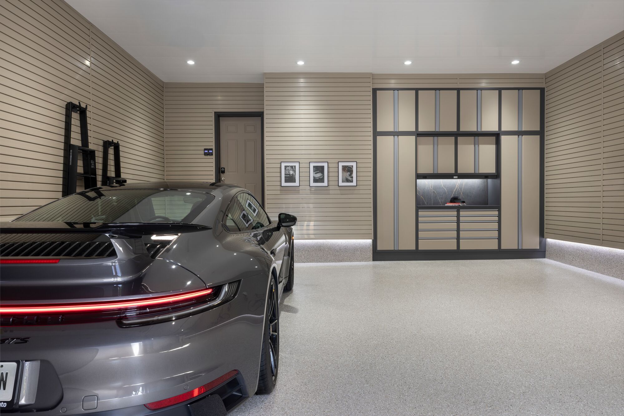 Porsche 911 in a contemporary garage with integrated lighting, organized storage, and gray-blue finishes