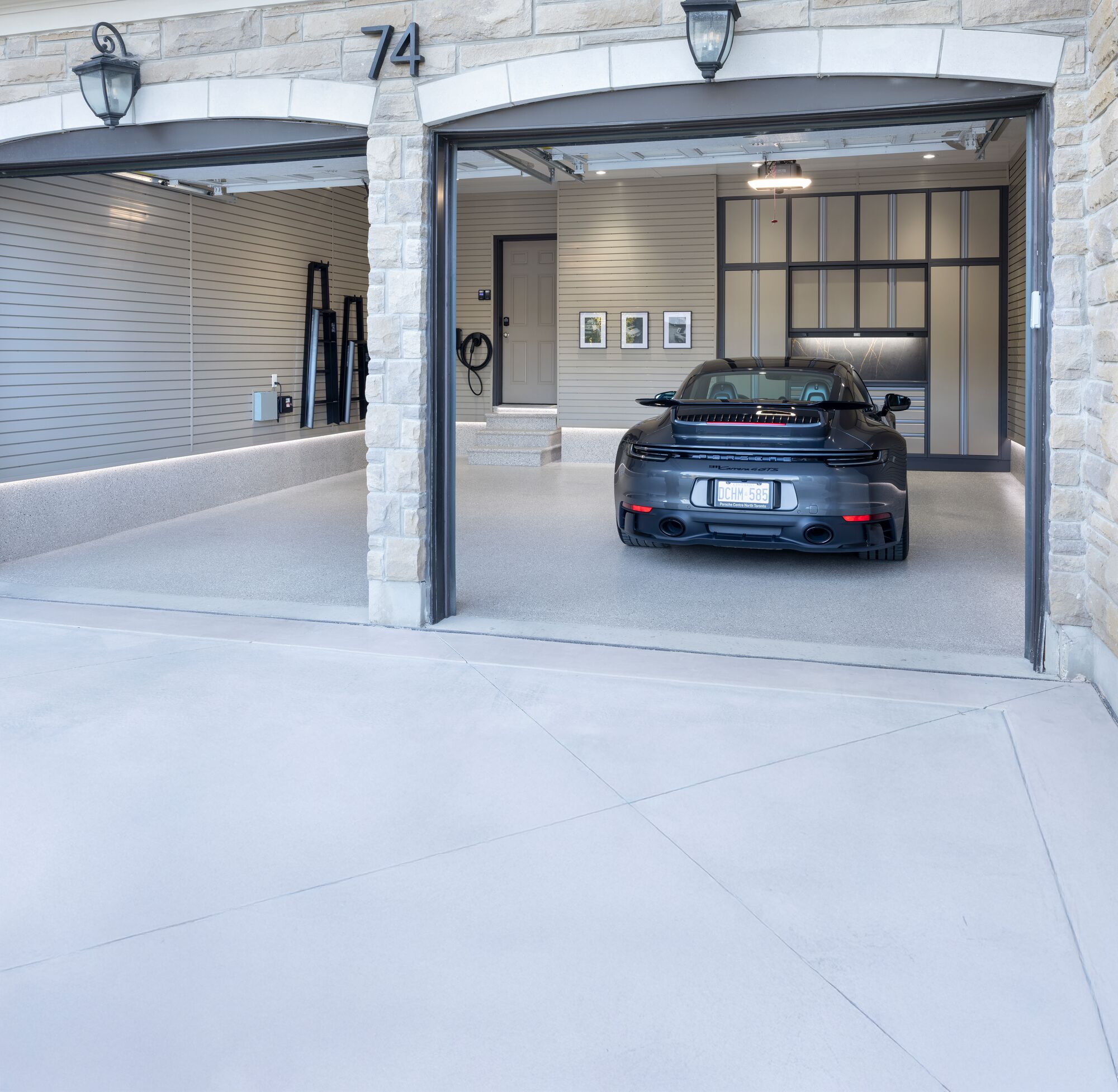 Custom garage featuring a Porsche 911, full-wall storage cabinetry, and matching slatwall organization