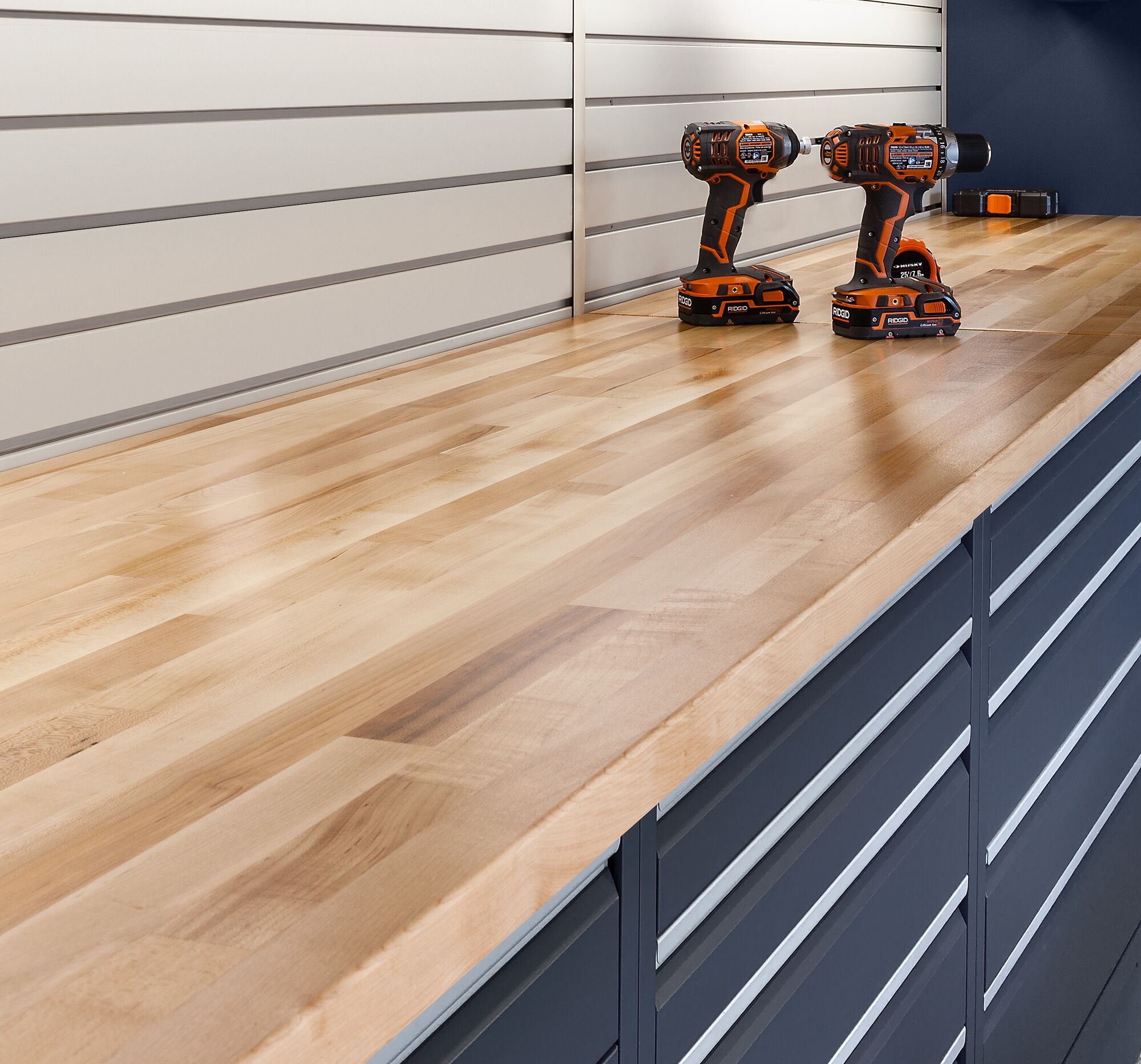 Porsche 911 parked inside a custom garage with blue-gray flooring, slatwall panels, and built-in cabinetry